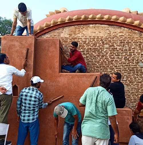 Students Applying Thappi plaster during a lime plaster workshop in. India