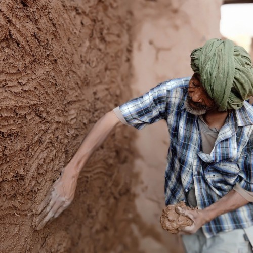Earthen plastering during natural building workshop Morocco