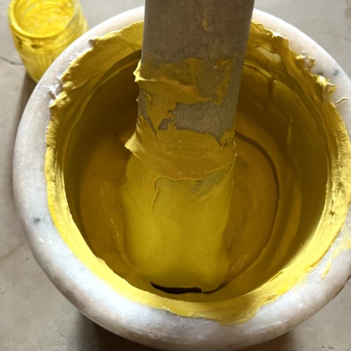 Arish plaster  being ground by hand with yellow pigment natural yellow pigment